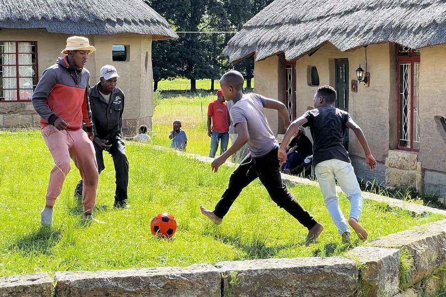Scholars playing football outside the cottages